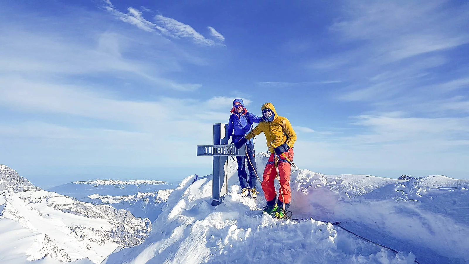 Ski tourers at the summit cross of the Finsteraarhorn.